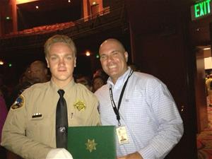 An officer and an instructor holding a completion certificate